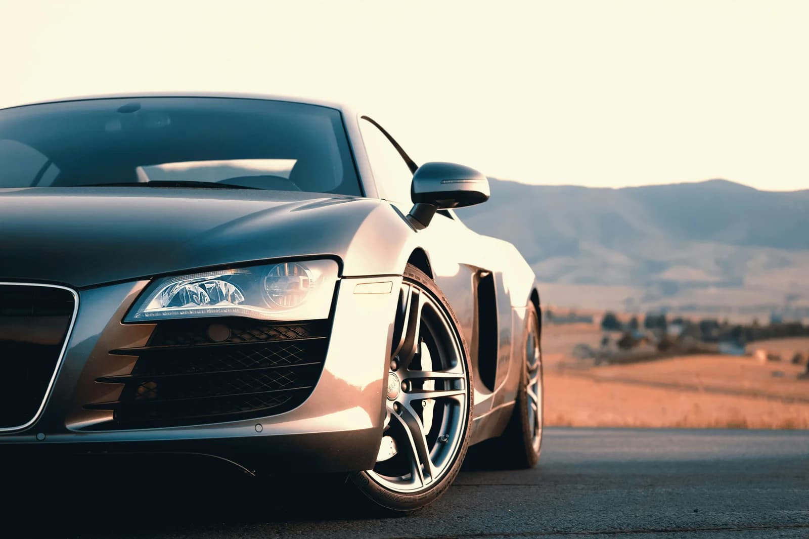 Sports car parked on an open road at sunset